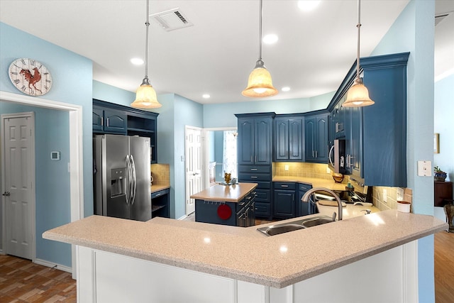 kitchen featuring sink, blue cabinetry, stainless steel appliances, and kitchen peninsula