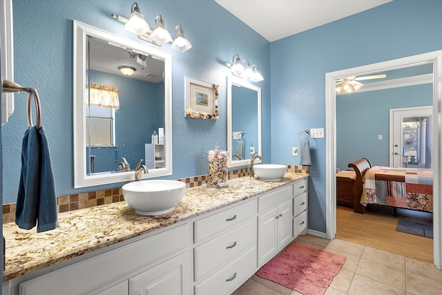 bathroom featuring tile patterned flooring, vanity, and decorative backsplash