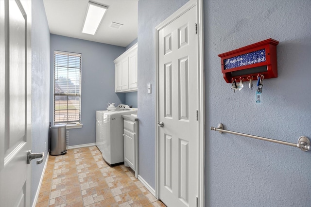 laundry room featuring cabinets and washer and dryer