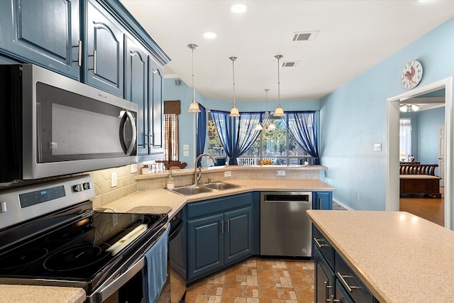 kitchen with blue cabinetry, appliances with stainless steel finishes, sink, and decorative light fixtures