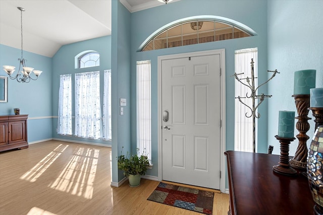 entryway featuring lofted ceiling, an inviting chandelier, and light hardwood / wood-style flooring