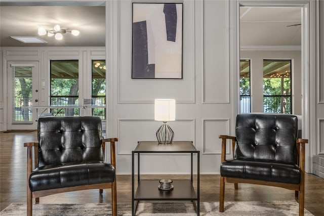 sitting room featuring plenty of natural light, crown molding, and wood-type flooring