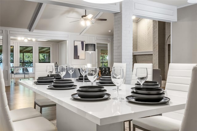 kitchen with a breakfast bar, beamed ceiling, ceiling fan, crown molding, and hardwood / wood-style flooring