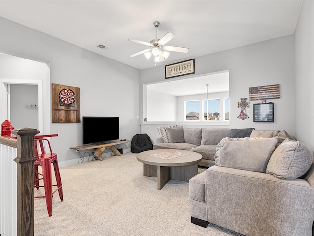 carpeted living room with baseboards, visible vents, and a ceiling fan