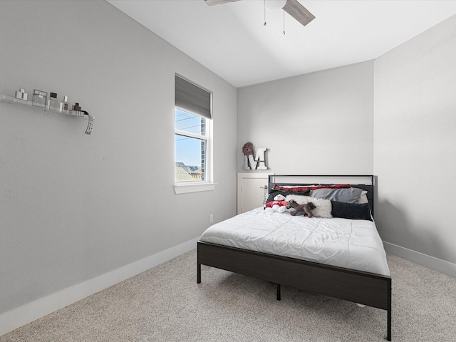 carpeted bedroom with ceiling fan and baseboards