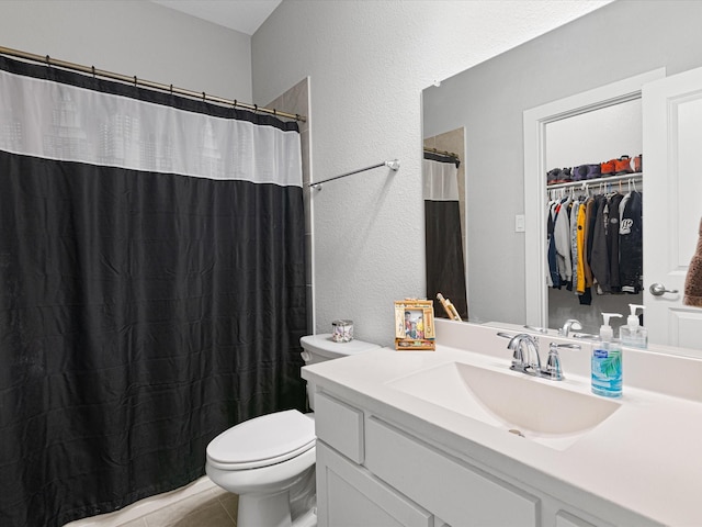 bathroom with toilet, a walk in closet, vanity, and a shower with curtain