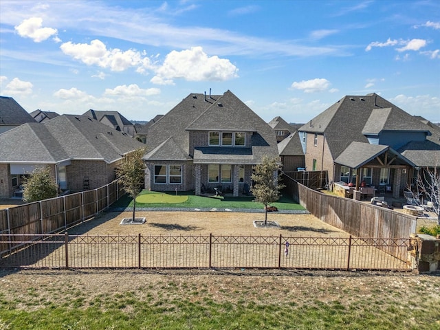 back of property with a fenced backyard and a residential view