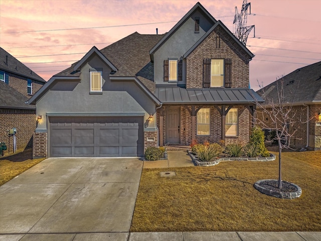 traditional-style house with driveway, brick siding, a standing seam roof, and a front yard