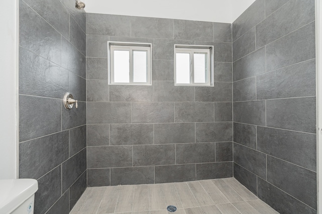 full bathroom with toilet and a tile shower