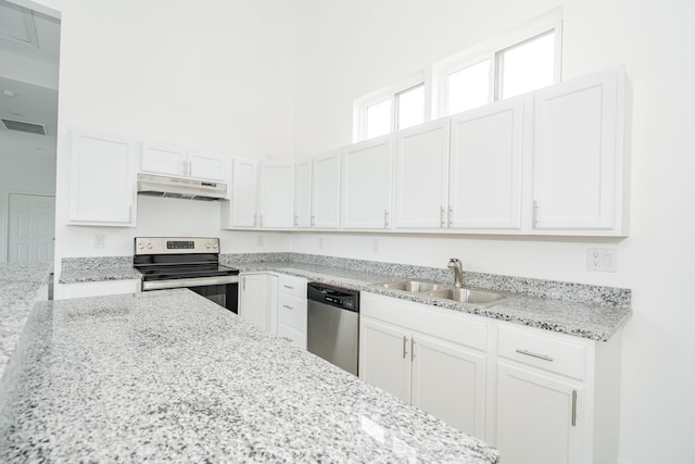 kitchen featuring visible vents, appliances with stainless steel finishes, under cabinet range hood, white cabinetry, and a sink