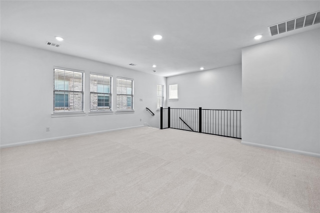 unfurnished room with recessed lighting, visible vents, and light carpet