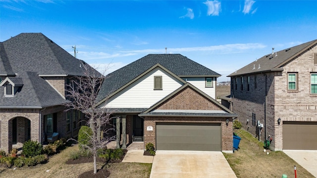 view of front of home featuring a shingled roof, concrete driveway, and brick siding