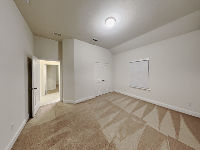 carpeted spare room with lofted ceiling and a textured ceiling