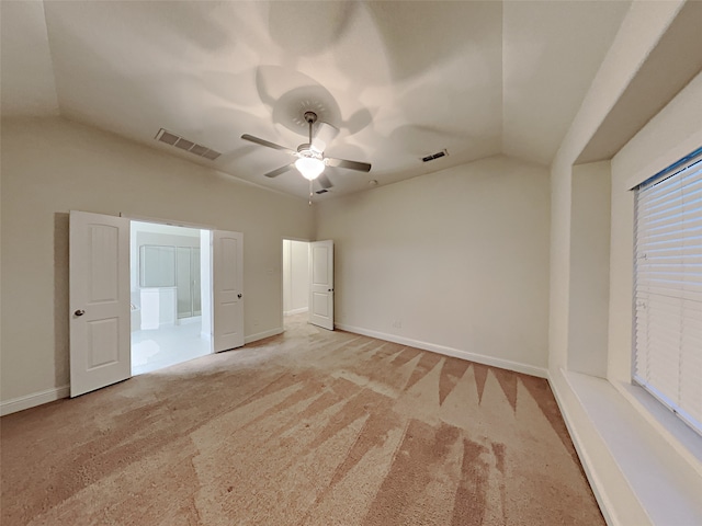 unfurnished bedroom featuring light carpet, lofted ceiling, and ceiling fan