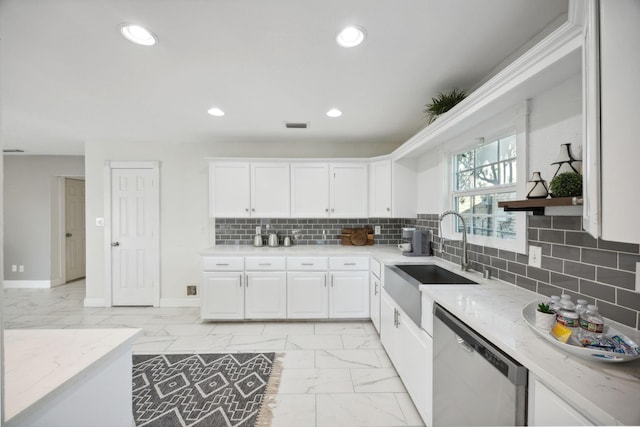 kitchen with sink, backsplash, stainless steel dishwasher, white cabinets, and light stone countertops