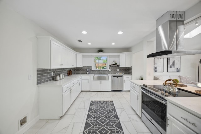 kitchen featuring appliances with stainless steel finishes, white cabinetry, and island exhaust hood