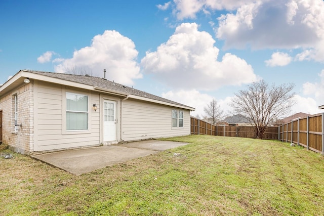 back of house with a patio area and a lawn