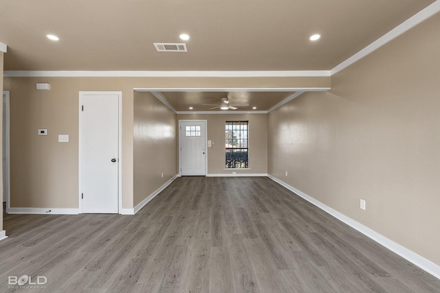 unfurnished living room with ceiling fan, ornamental molding, and light hardwood / wood-style floors