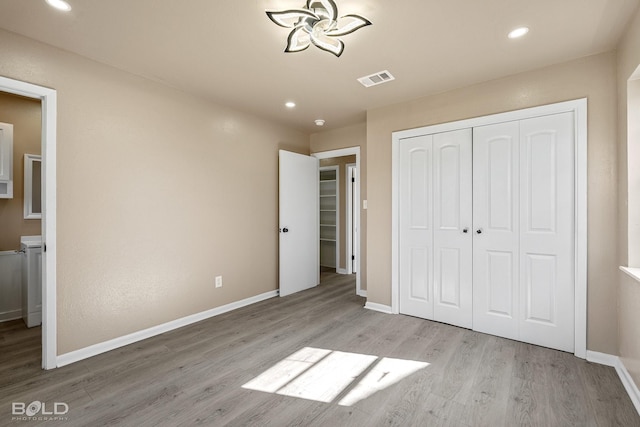 unfurnished bedroom with a closet and light hardwood / wood-style floors