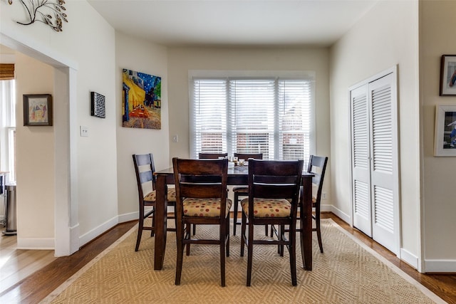 dining space featuring baseboards and wood finished floors