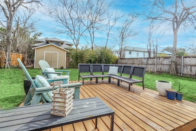 wooden terrace with an outbuilding, a fenced backyard, a yard, and a shed