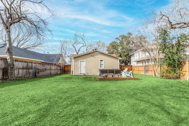 back of property with a yard, a fenced backyard, and a wooden deck