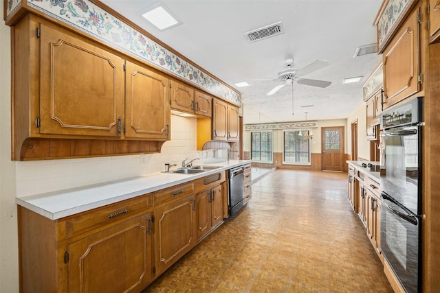 kitchen with double oven, dishwashing machine, ceiling fan, decorative light fixtures, and sink