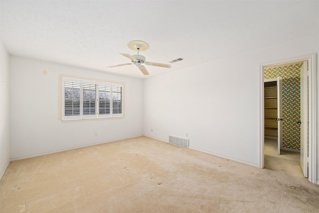 unfurnished room with ceiling fan and light carpet