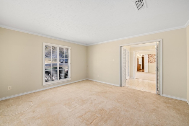 empty room featuring ornamental molding, light carpet, and a textured ceiling