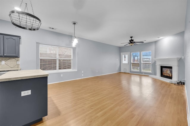 unfurnished living room featuring light wood-type flooring and ceiling fan