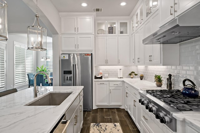 kitchen with appliances with stainless steel finishes, sink, decorative light fixtures, dark hardwood / wood-style flooring, and white cabinets