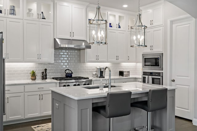 kitchen featuring stainless steel appliances, a kitchen island with sink, and white cabinets