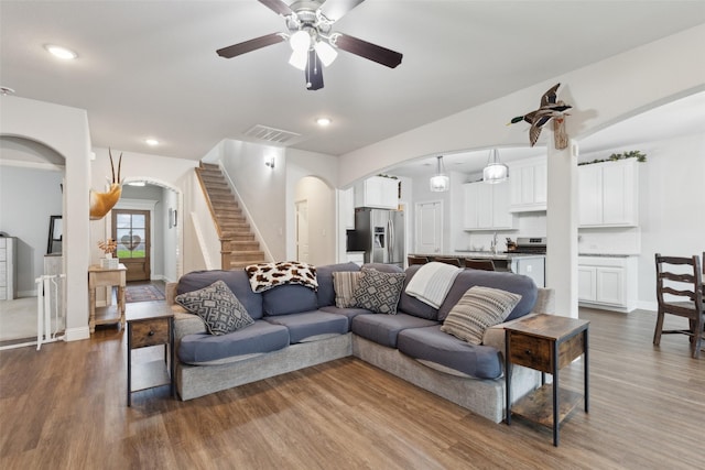 living room featuring hardwood / wood-style floors, ceiling fan, and sink