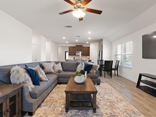 living room with recessed lighting, visible vents, light wood-style floors, ceiling fan, and baseboards