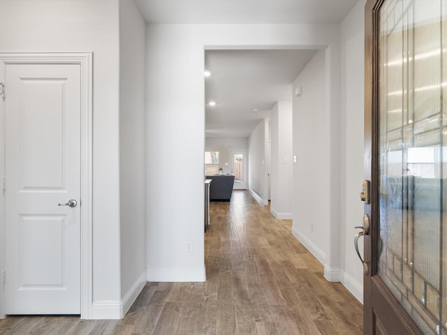 hall featuring wood finished floors and baseboards