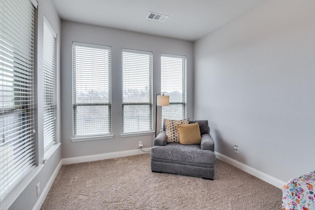 living area featuring baseboards, visible vents, and carpet flooring