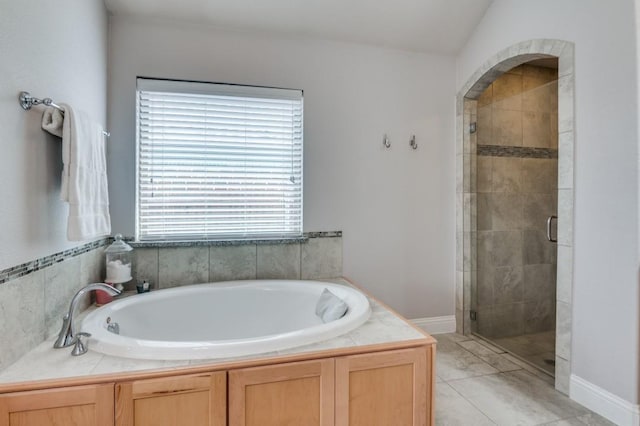 bathroom with a stall shower and a bath