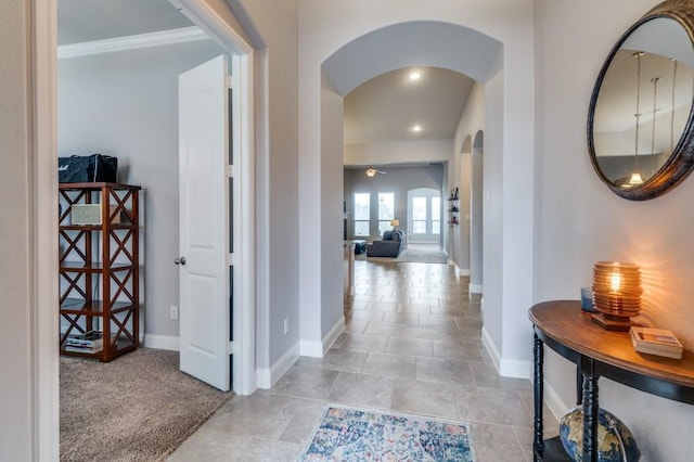 hallway featuring recessed lighting, light carpet, baseboards, and arched walkways