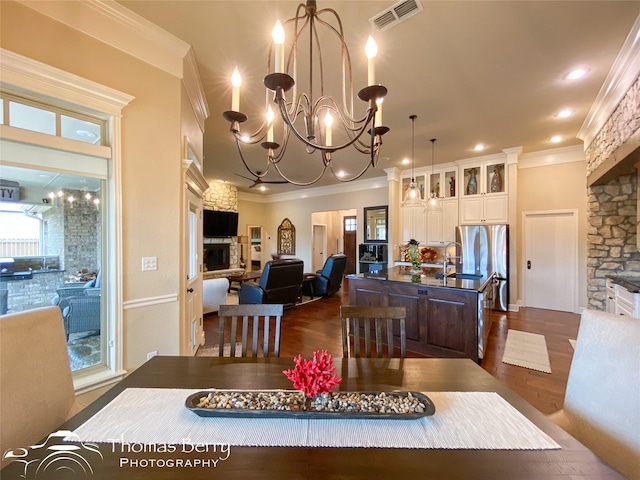 dining room featuring a notable chandelier, recessed lighting, visible vents, dark wood-style floors, and crown molding