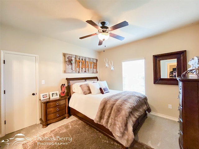 bedroom featuring light carpet, a ceiling fan, and baseboards