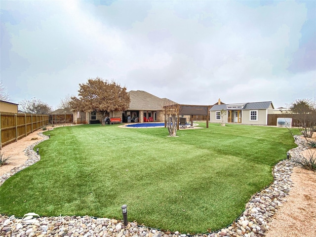 view of yard featuring an outbuilding, a patio, and a fenced backyard