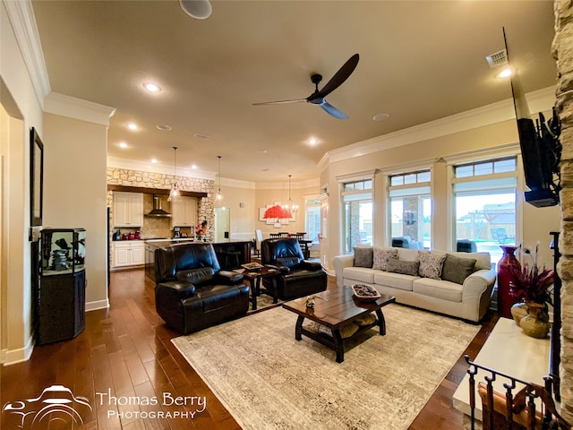 living area with dark wood-style floors, ceiling fan, ornamental molding, and recessed lighting