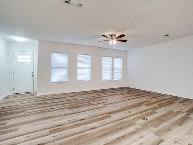 unfurnished living room with light wood finished floors, ceiling fan, baseboards, and visible vents