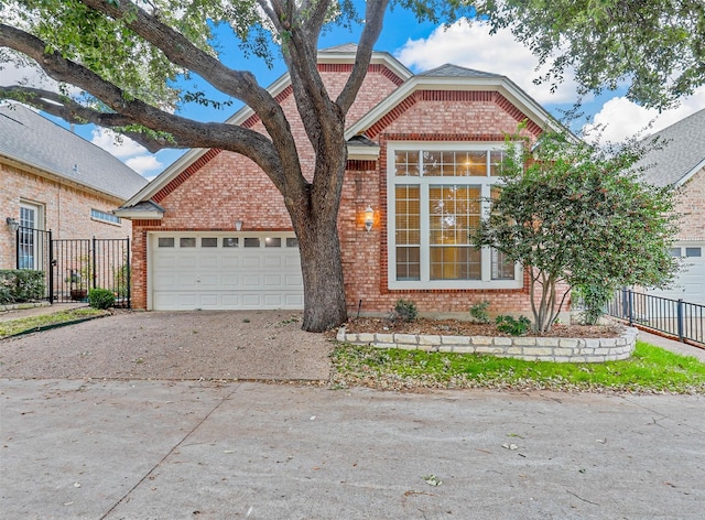 view of front facade with brick siding, driveway, fence, and a garage