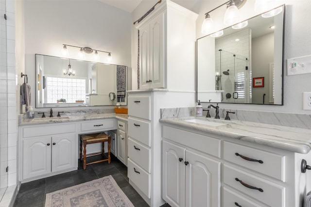 full bathroom with a chandelier, a stall shower, and vanity