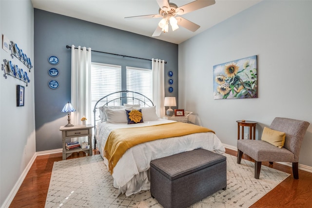 bedroom featuring a ceiling fan, baseboards, and wood finished floors