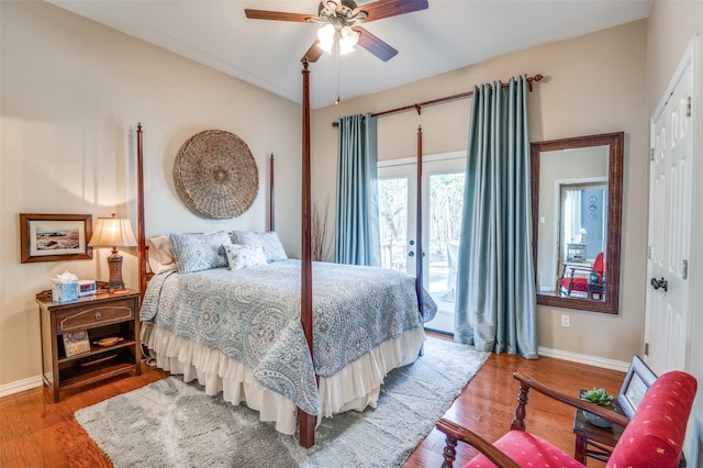 bedroom featuring access to outside, a closet, baseboards, and wood finished floors