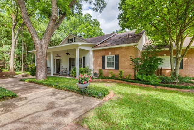 view of front of house featuring a front lawn, brick siding, and ceiling fan