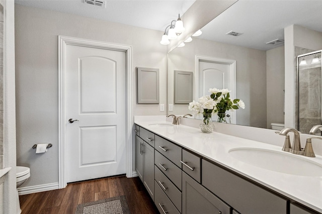 full bathroom with toilet, visible vents, a sink, and wood finished floors