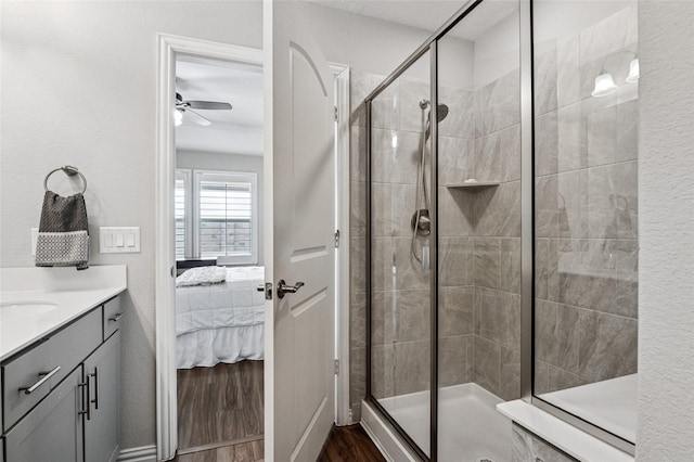 full bathroom with ensuite bathroom, a ceiling fan, a shower stall, vanity, and wood finished floors